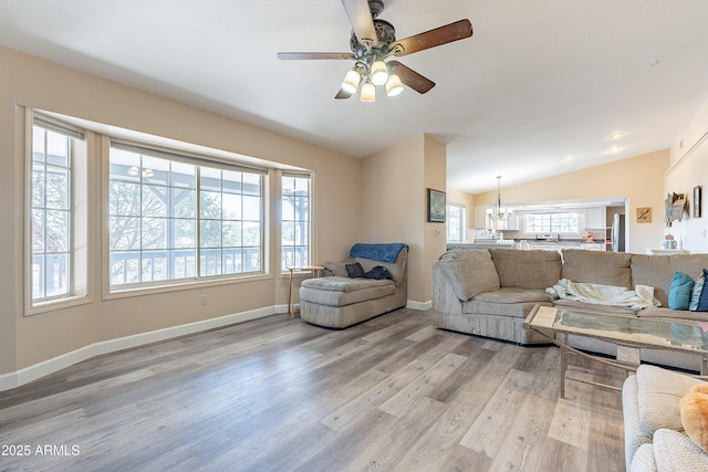 living room featuring lofted ceiling, plenty of natural light, baseboards, and light wood-style flooring