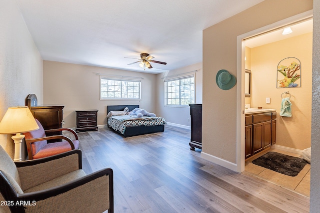 bedroom with light wood-style floors, baseboards, and a ceiling fan