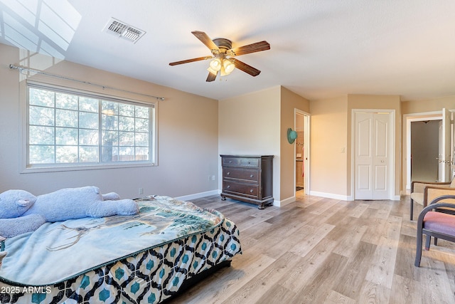 bedroom featuring baseboards, visible vents, ceiling fan, and light wood finished floors