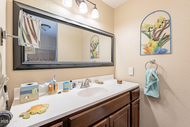 bathroom with a textured wall and vanity