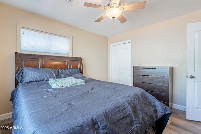 bedroom featuring a ceiling fan, a closet, baseboards, and wood finished floors