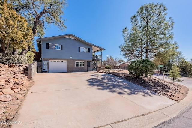 view of front of house with a garage, driveway, and stairway