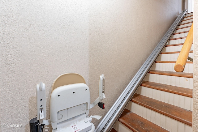 staircase featuring a textured wall