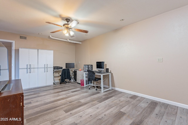 office area with light wood-style floors, visible vents, ceiling fan, and baseboards