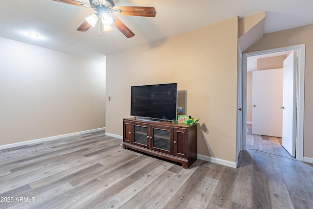 living area with ceiling fan, baseboards, and wood finished floors