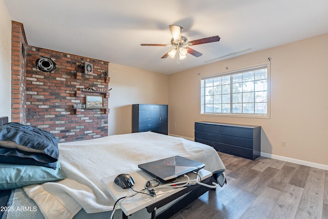 bedroom with ceiling fan, wood finished floors, and baseboards