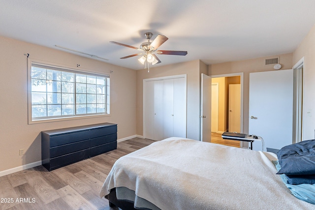 bedroom with a ceiling fan, a closet, baseboards, and wood finished floors