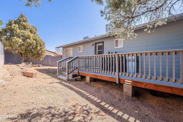 back of house with a chimney, fence, and a wooden deck