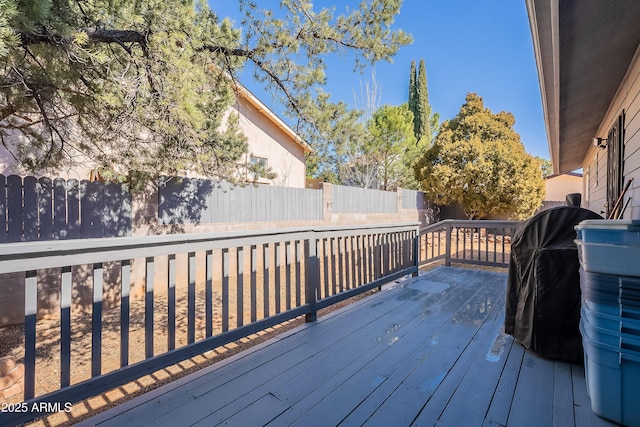 wooden terrace featuring a fenced backyard and a grill