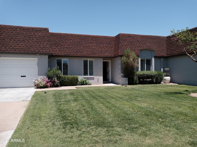 single story home featuring a front lawn and a garage