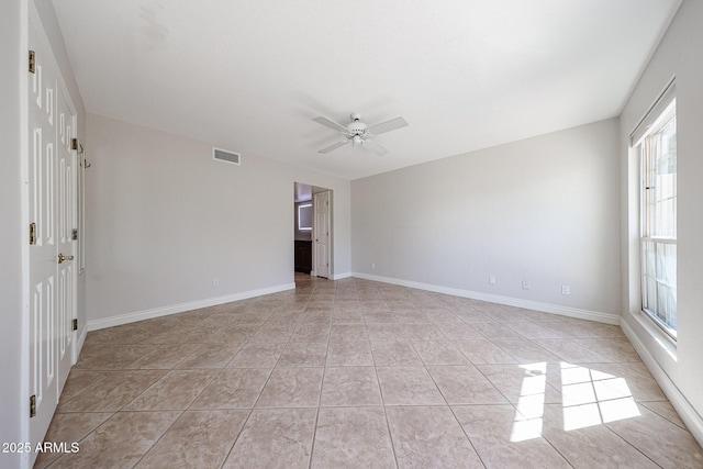 unfurnished room featuring baseboards, visible vents, a ceiling fan, and light tile patterned floors