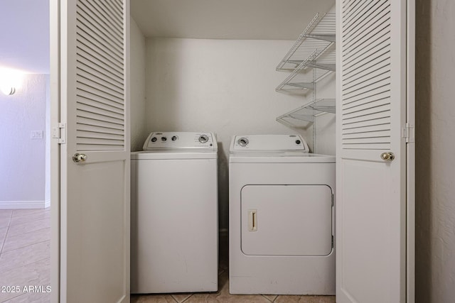 laundry room with laundry area, washing machine and dryer, and light tile patterned floors