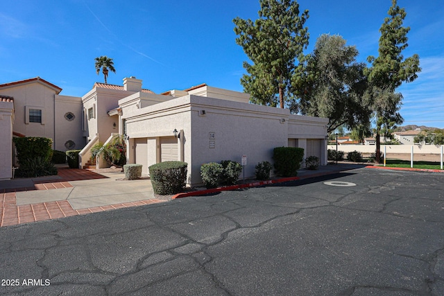 exterior space with a garage, driveway, stairway, and stucco siding