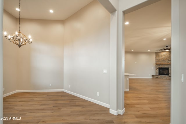 14110 E Hard Rock Rd, Prescott Valley, AZ 86315 - spare room featuring wood finished floors, a chandelier, recessed lighting, ceiling fan, and a stone fireplace