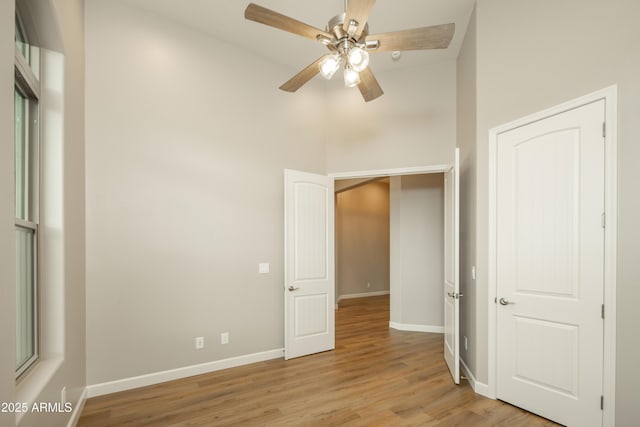 14110 E Hard Rock Rd, Prescott Valley, AZ 86315 - unfurnished bedroom with baseboards, wood finished floors, a high ceiling, and ceiling fan