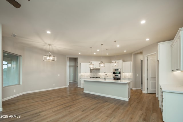 14110 E Hard Rock Rd, Prescott Valley, AZ 86315 - kitchen with recessed lighting, backsplash, light countertops, a center island with sink, and white cabinetry