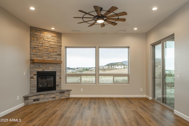 14110 E Hard Rock Rd, Prescott Valley, AZ 86315 - unfurnished living room featuring healthy amount of natural light, wood finished floors, ceiling fan, a stone fireplace, and recessed lighting