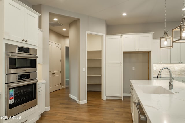 14110 E Hard Rock Rd, Prescott Valley, AZ 86315 - kitchen with a sink, double oven, wood finished floors, white cabinets, and recessed lighting