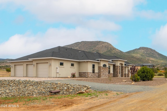 14110 E Hard Rock Rd, Prescott Valley, AZ 86315 - view of front facade featuring a mountain view, a garage, stucco siding, and stone siding