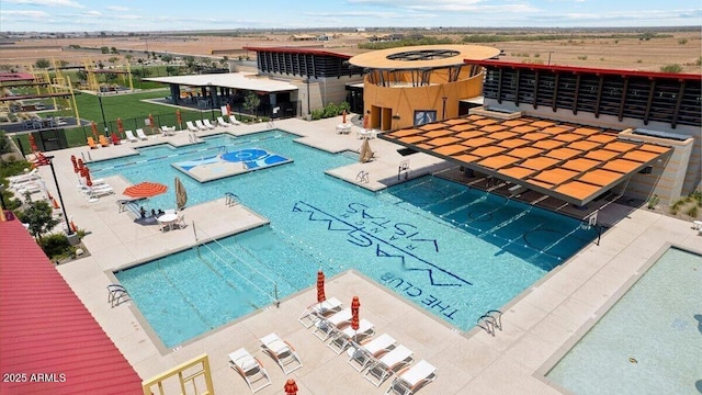 community pool featuring fence and a patio