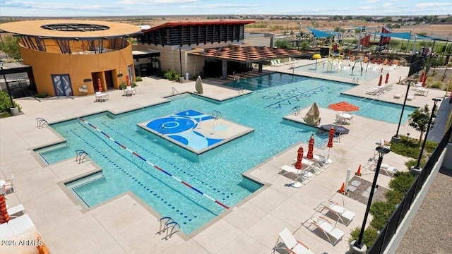 pool with a patio area and fence