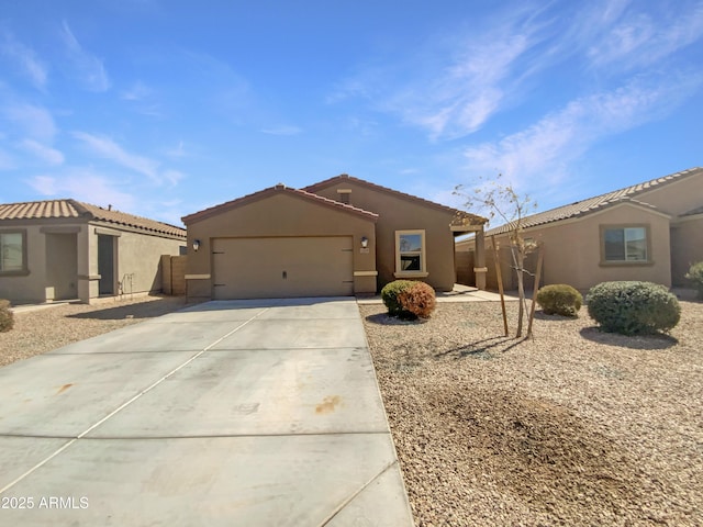 view of front of home with a tiled roof, stucco siding, driveway, and a garage