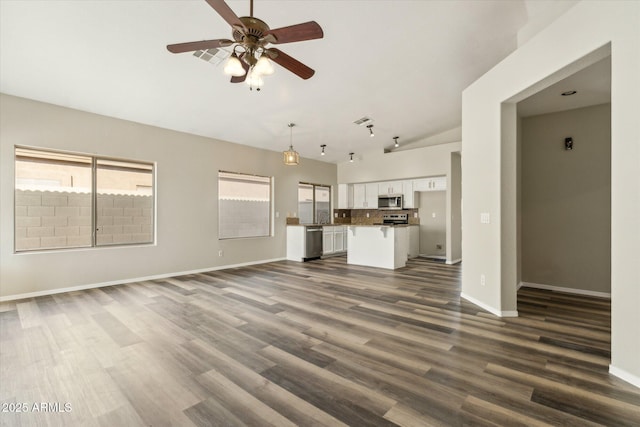 6658 E San Cristobal Way, Gold Canyon, AZ 85118 - unfurnished living room with a ceiling fan, dark wood-style floors, baseboards, high vaulted ceiling, and a sink