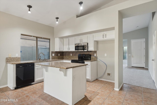 kitchen featuring light stone countertops, a center island, black appliances, and lofted ceiling