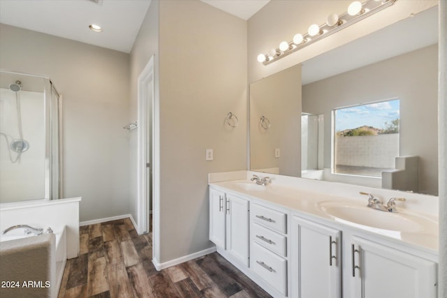 bathroom with a washtub, hardwood / wood-style floors, and vanity