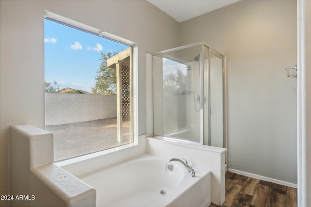 bathroom with independent shower and bath and hardwood / wood-style flooring