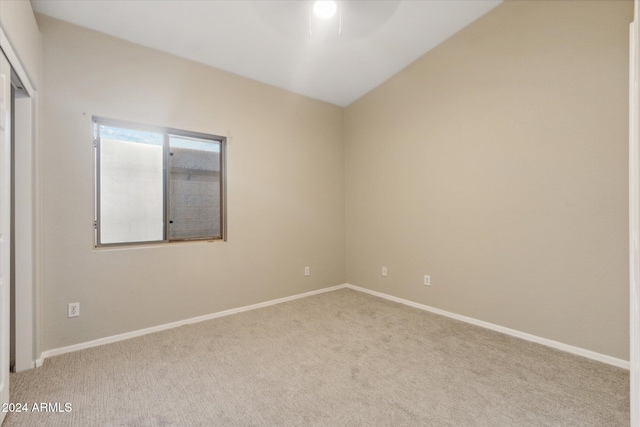 unfurnished room with ceiling fan, light colored carpet, and lofted ceiling