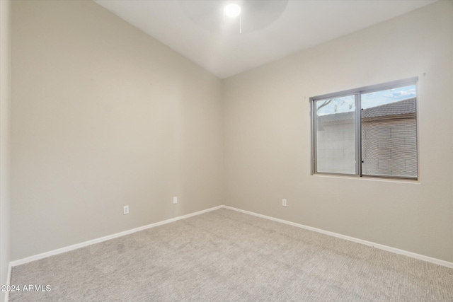 carpeted spare room with lofted ceiling