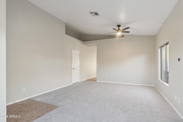 unfurnished room featuring ceiling fan, light colored carpet, and vaulted ceiling