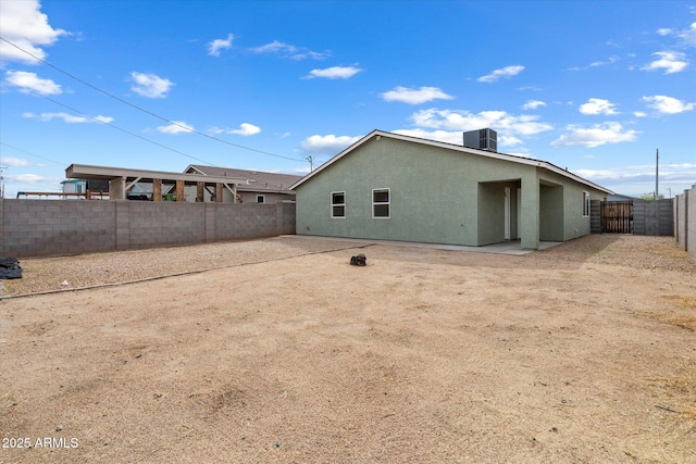 rear view of house featuring a patio, a fenced backyard, stucco siding, and central AC unit
