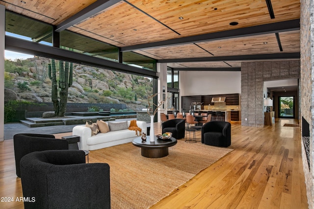 living room featuring lofted ceiling with beams, a wealth of natural light, wooden ceiling, and wood-type flooring