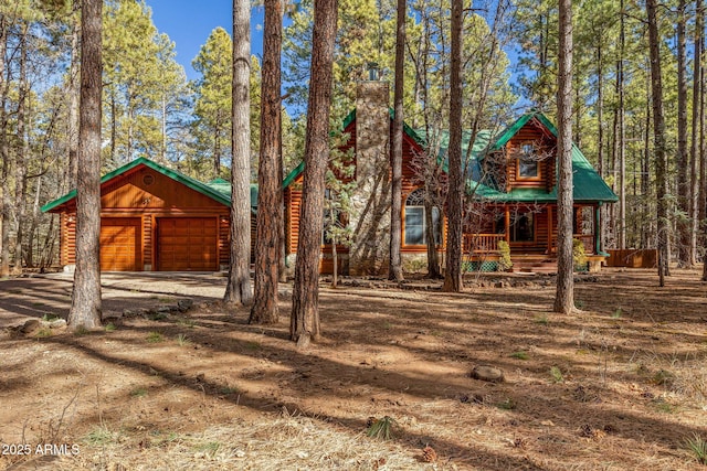 log-style house featuring a garage and covered porch