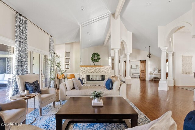 10205 E Corrine Dr, Scottsdale, AZ 85260 - living room with decorative columns, high vaulted ceiling, arched walkways, wood finished floors, and beamed ceiling