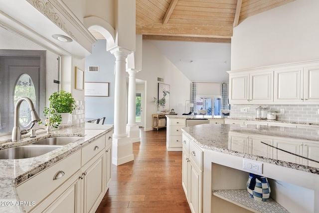 10205 E Corrine Dr, Scottsdale, AZ 85260 - kitchen with a sink, ornate columns, wood finished floors, tasteful backsplash, and high vaulted ceiling