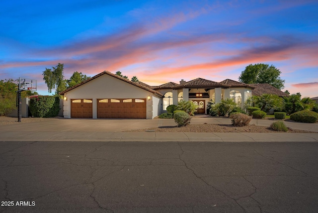 10205 E Corrine Dr, Scottsdale, AZ 85260 - mediterranean / spanish-style home with an attached garage, concrete driveway, stucco siding, a tile roof, and a chimney