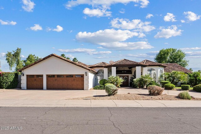 10205 E Corrine Dr, Scottsdale, AZ 85260 - mediterranean / spanish house with an attached garage, stucco siding, driveway, and a tiled roof