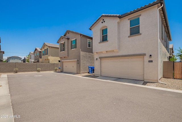 5812 W Illini St, Phoenix, AZ 85043 - view of front of home with a garage, stucco siding, a residential view, and driveway