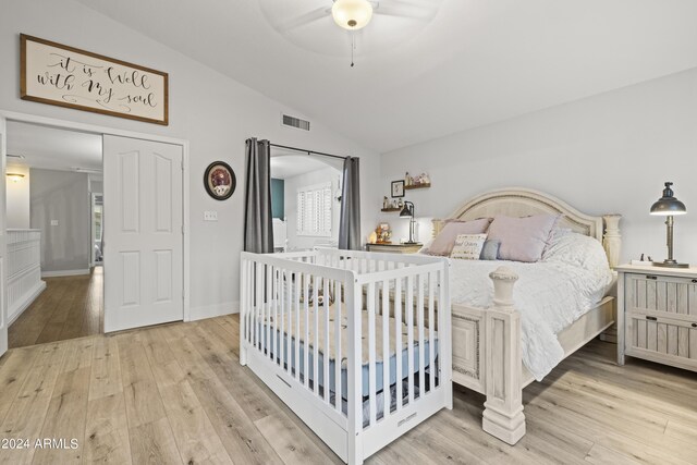 bedroom featuring light wood-type flooring, lofted ceiling, and ceiling fan