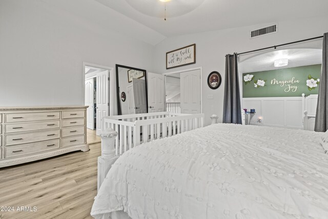 bedroom featuring light wood-type flooring, vaulted ceiling, and ceiling fan