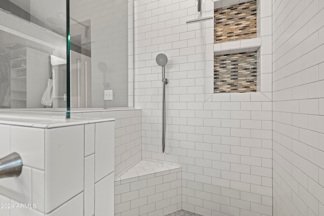 bathroom with tiled shower and washer / clothes dryer