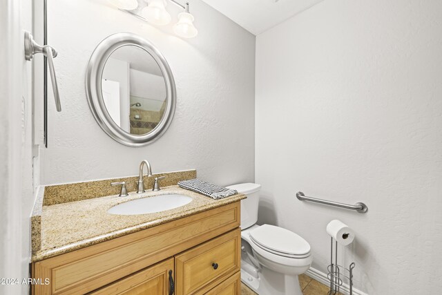 bathroom featuring tile patterned floors, vanity, and toilet