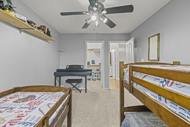 carpeted bedroom featuring a spacious closet, a closet, and ceiling fan