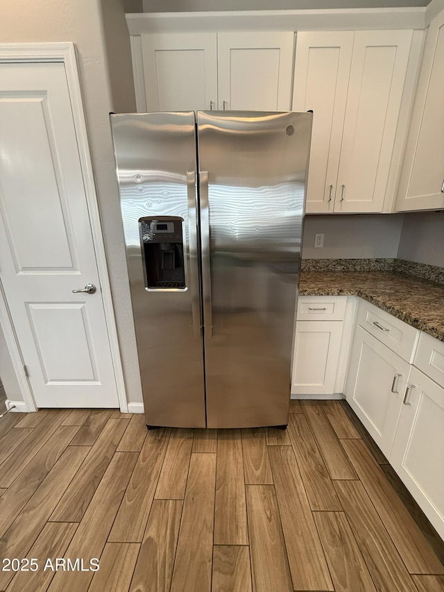 1720 W Pollack St, Phoenix, AZ 85041 - kitchen with stainless steel refrigerator with ice dispenser, light wood-type flooring, white cabinets, and dark stone counters