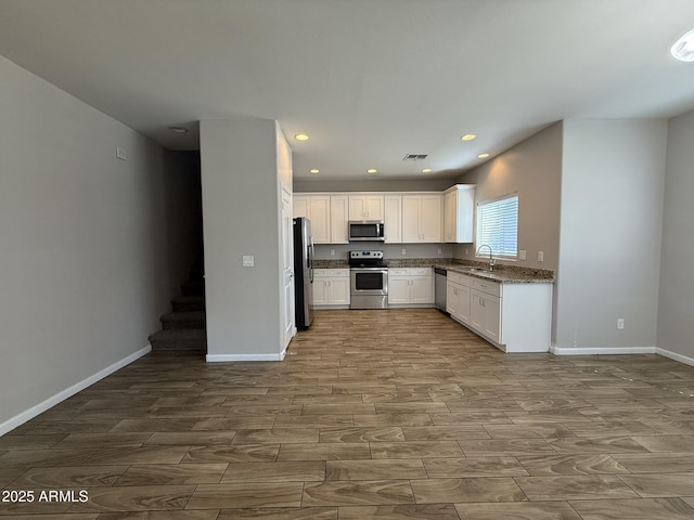 1720 W Pollack St, Phoenix, AZ 85041 - kitchen featuring stainless steel appliances, wood tiled floors, a sink, white cabinetry, and baseboards