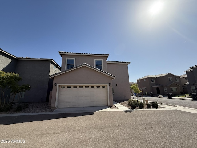 1720 W Pollack St, Phoenix, AZ 85041 - mediterranean / spanish house featuring stucco siding, an attached garage, a tiled roof, and a residential view