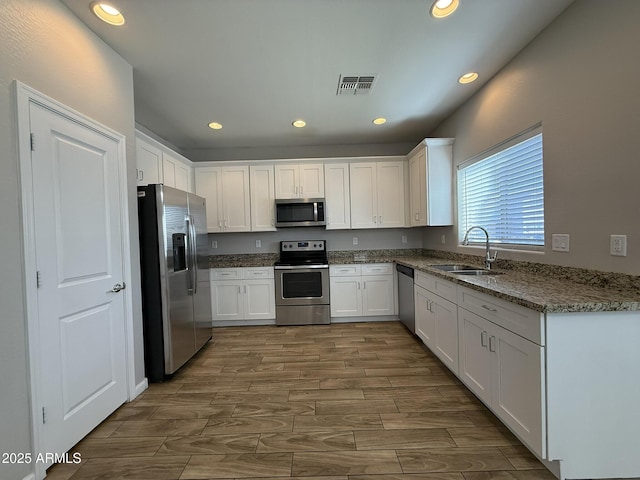 1720 W Pollack St, Phoenix, AZ 85041 - kitchen with appliances with stainless steel finishes, a sink, white cabinets, and recessed lighting